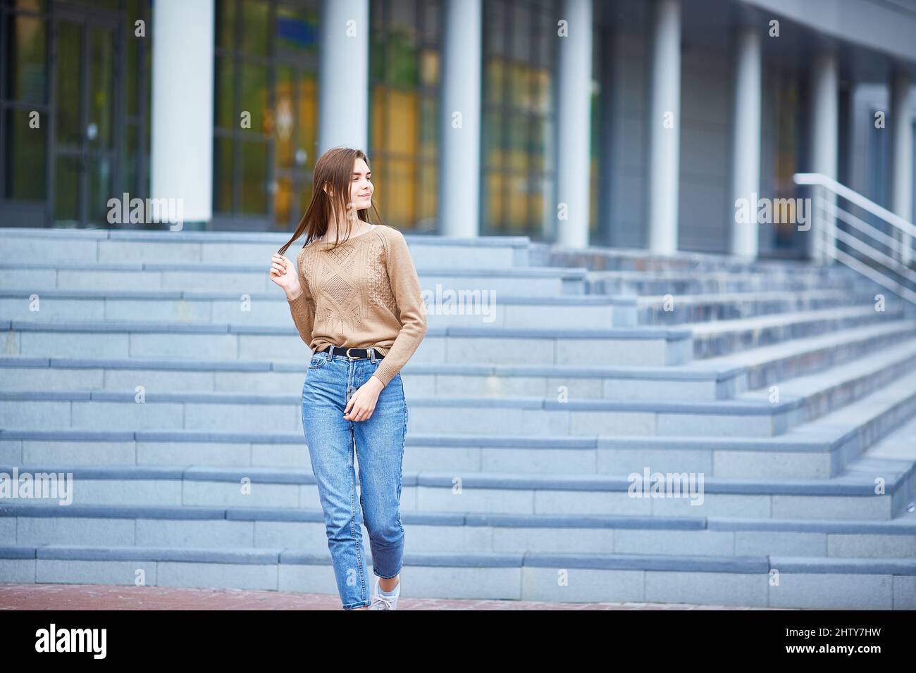 teenage girl descends the steps of the institute. Higher education, the beginning of the school year, back to school. Copyspace. Stock Photo