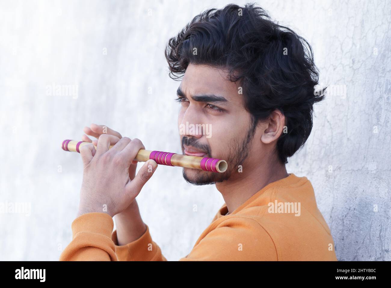 Indian boy playing bansuri Indian Bamboo Flute. Stock Photo