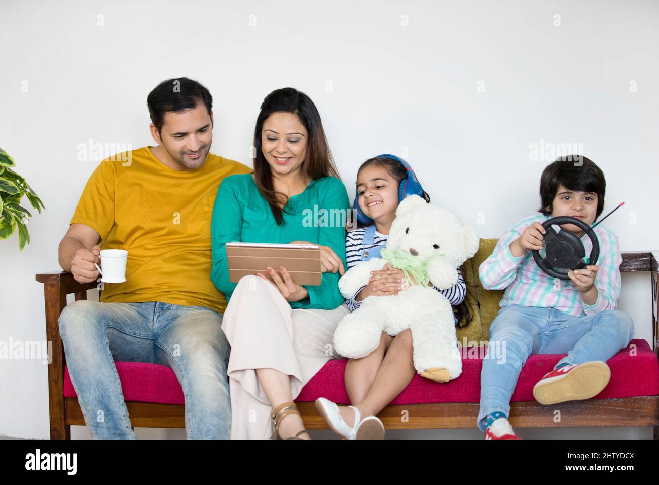 Father and mother playing with their kids at home - Indian boy and girl. Small nuclear family in India - Happy family spending quality time with each Stock Photo