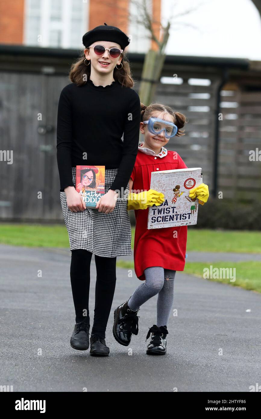 Chichester, West Sussex, UK. 03rd Mar, 2022. Florence, 6, dressed in red as Ada Twist Scientist, a book by Andrea Beaty and illustrated by David Roberts, and her sister Isabelle, 10, dressed in black as Agatha Oddlyon, a character in a book by Lena Jones. Both on their way to school dressed up and having fun on World Book Day. Credit: Sam Stephenson/Alamy Live News Stock Photo