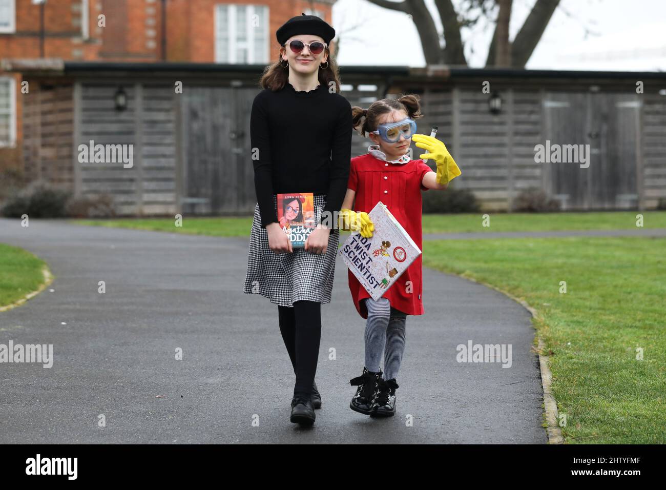 Chichester, West Sussex, UK. 03rd Mar, 2022. Florence, 6, dressed in red as Ada Twist Scientist, a book by Andrea Beaty and illustrated by David Roberts, and her sister Isabelle, 10, dressed in black as Agatha Oddlyon, a character in a book by Lena Jones. Both on their way to school dressed up and having fun on World Book Day. Credit: Sam Stephenson/Alamy Live News Stock Photo