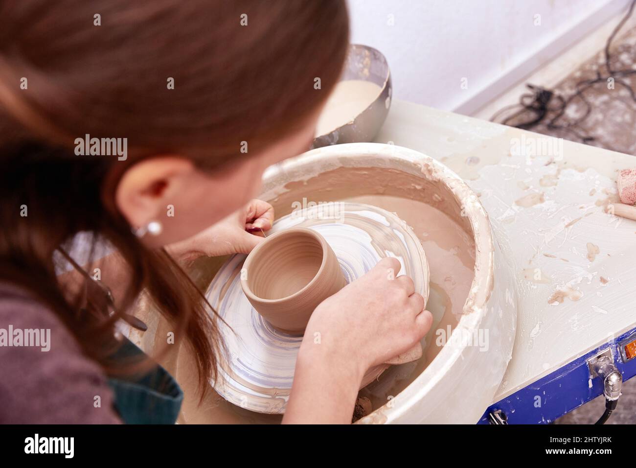 faceless woman makes dishes on a potter's wheel Stock Photo