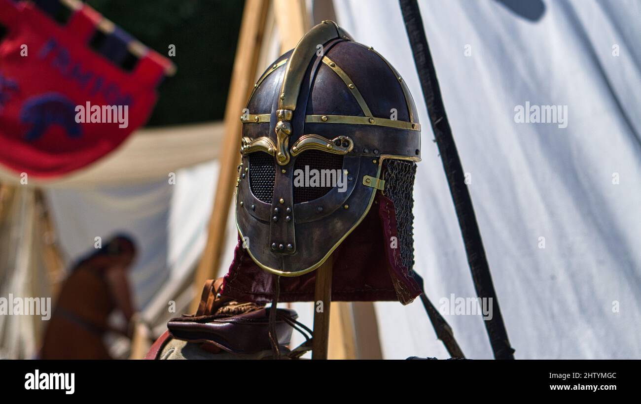 Medieval equipment, helmet, metal glove, armor. In the medieval spectacle you dive into past times. Show, jugglers and entertainment. Stock Photo