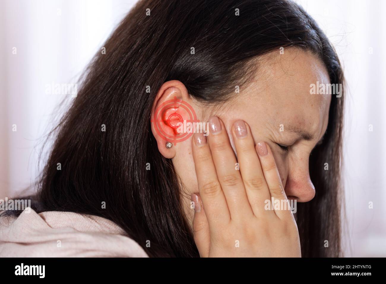 Young woman suffering of tinnitus disease, insomnia or stress concept, sick female having ear