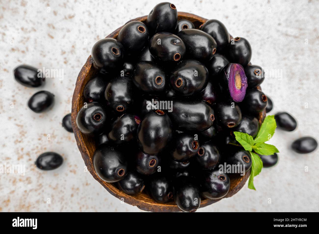 Black ripe Syzygium cumini fruits. Dark black java plum in a wood bowl