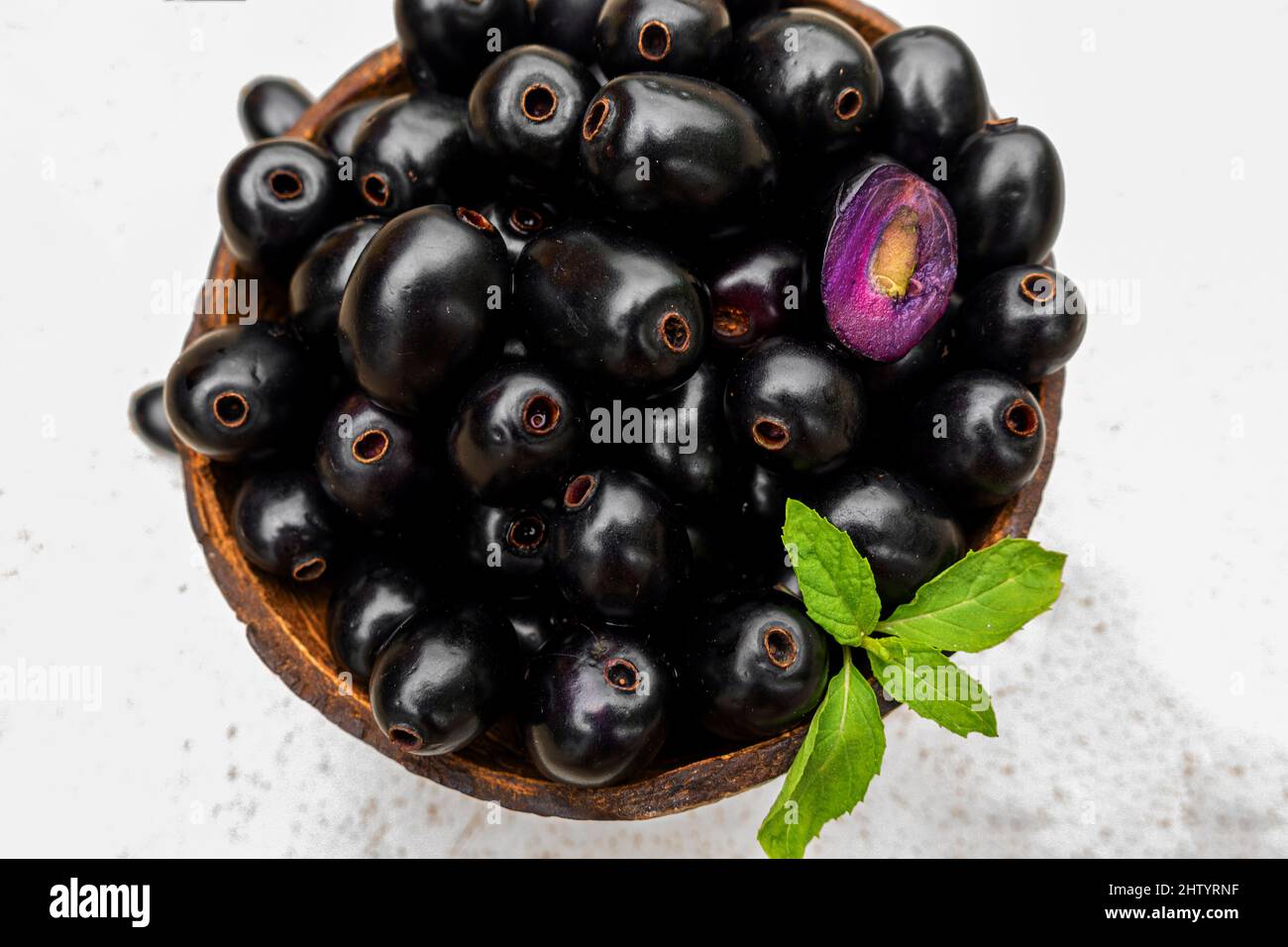 Black ripe Syzygium cumini fruits. Dark black java plum in a wood bowl