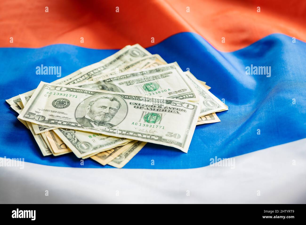 US dollar banknotes laid on the Russian flag. Stock Photo
