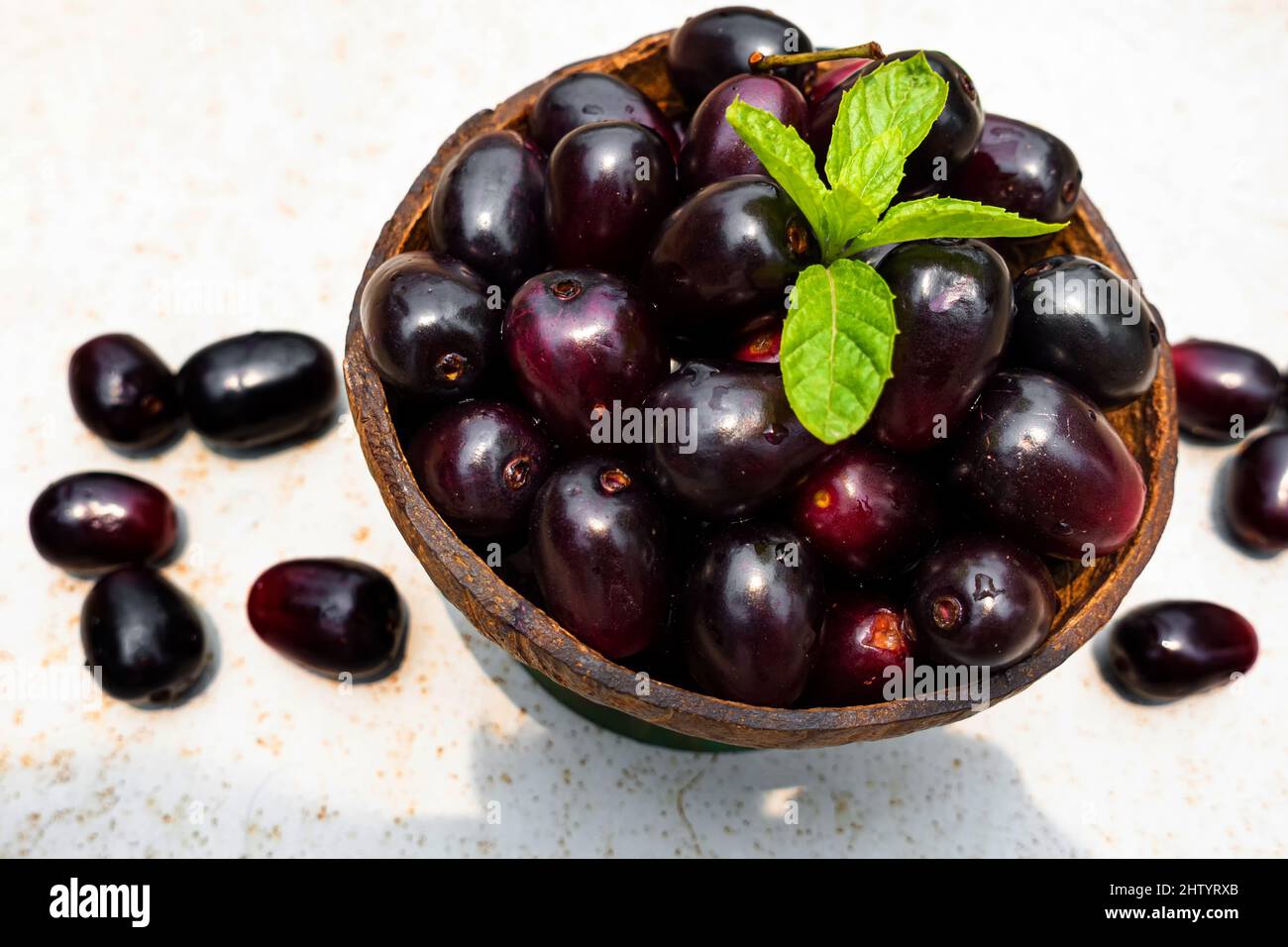 Dark pink-red ripe Syzygium cumini fruits. Dark black java plum in a ...
