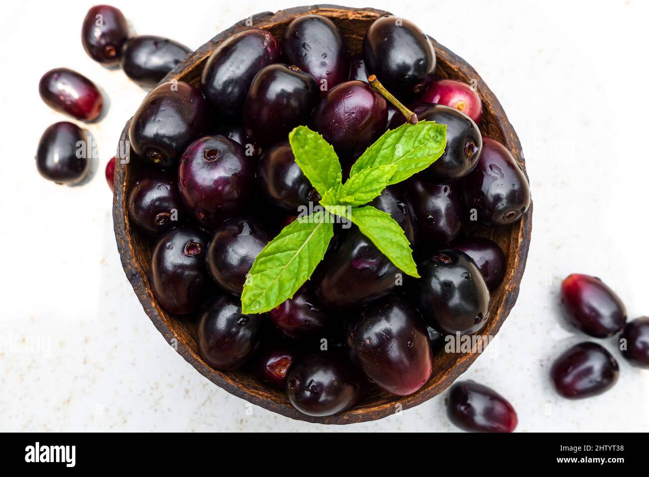 Dark pink-red ripe Syzygium cumini fruits. Dark black java plum in a ...