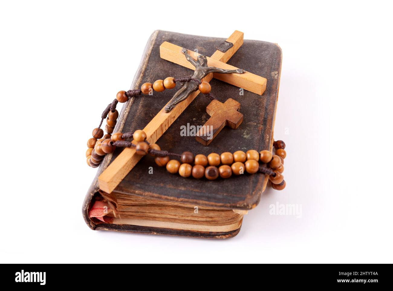 Old dusty prayer book, a cross and a rosary laying on top of it Christianity Catholicism traditional religious symbols, group of objects detail, close Stock Photo