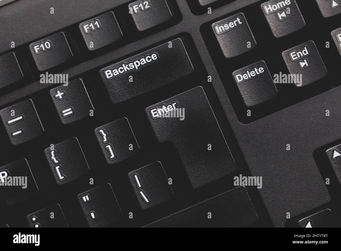 Simple modern black dark grey matte computer keyboard keys detail, background top view, enter key from above, nobody. Desktop PC keyboard minimal mode Stock Photo