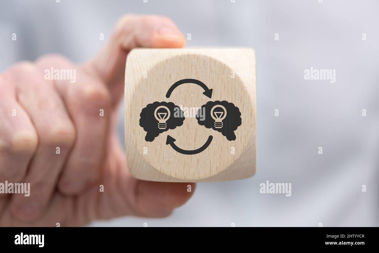Hand holding a wooden cube with symbol of knowledge sharing concept ...
