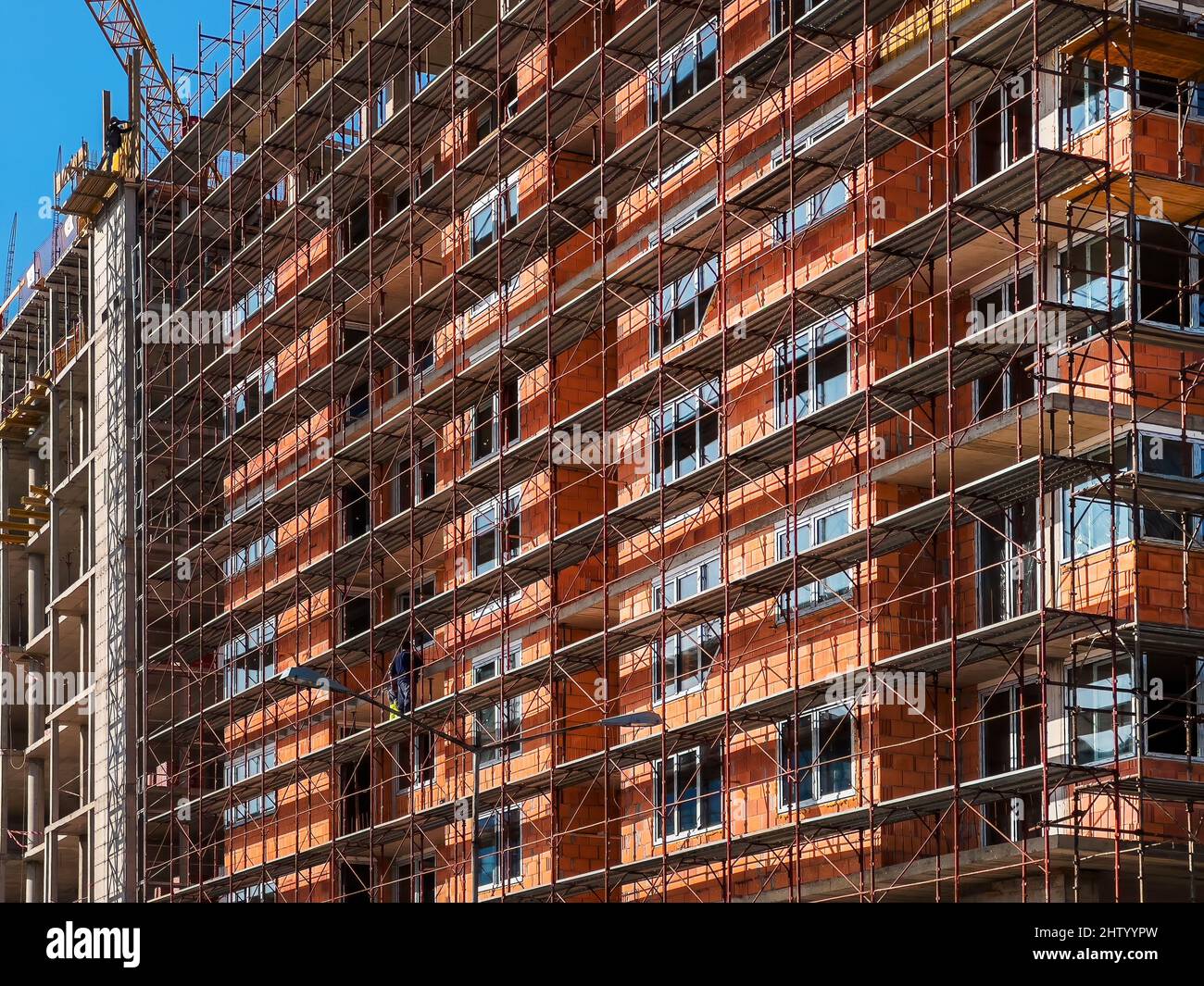 Curated visual reference: Durable And High Quality Apartment Building Construction Reference: Apartment Building Construction Site With Scaffolding And Crane Stock