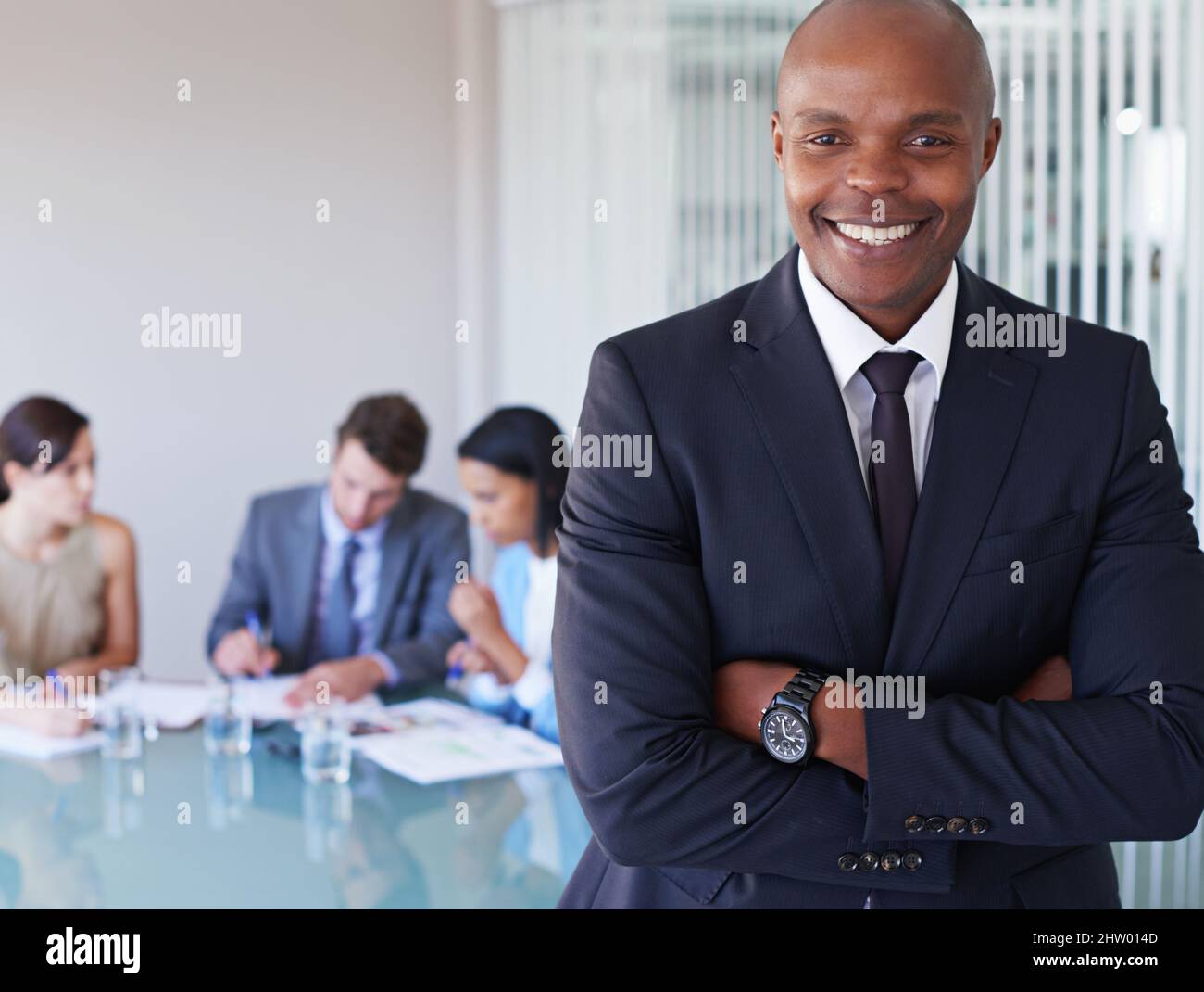 Climbing the corporate ladder. Portrait of a handsome businessman with his colleagues working in the background. Stock Photo