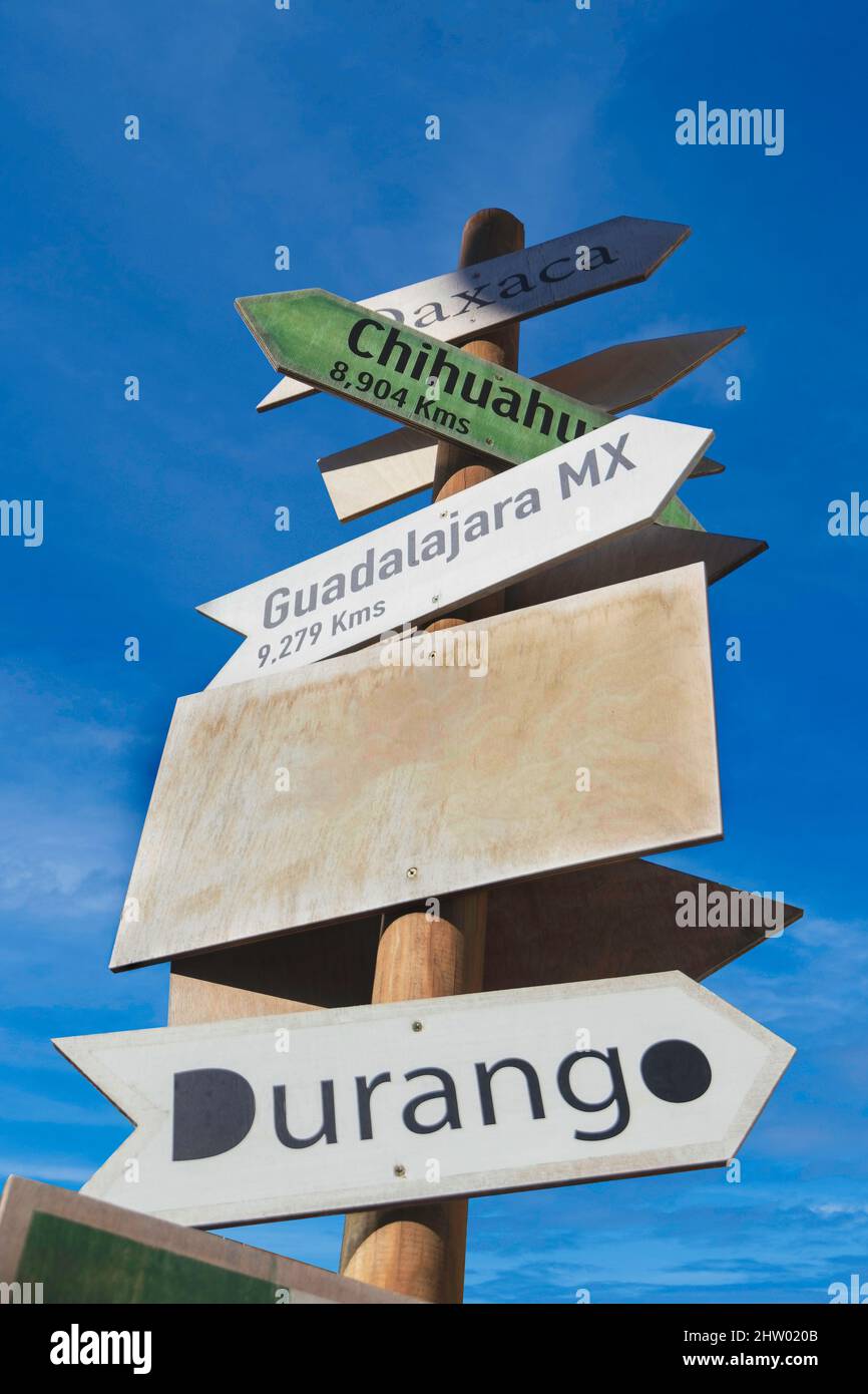 sign post with multiple arrows pointing to different locations in Mexico and a customizable blank banner Stock Photo