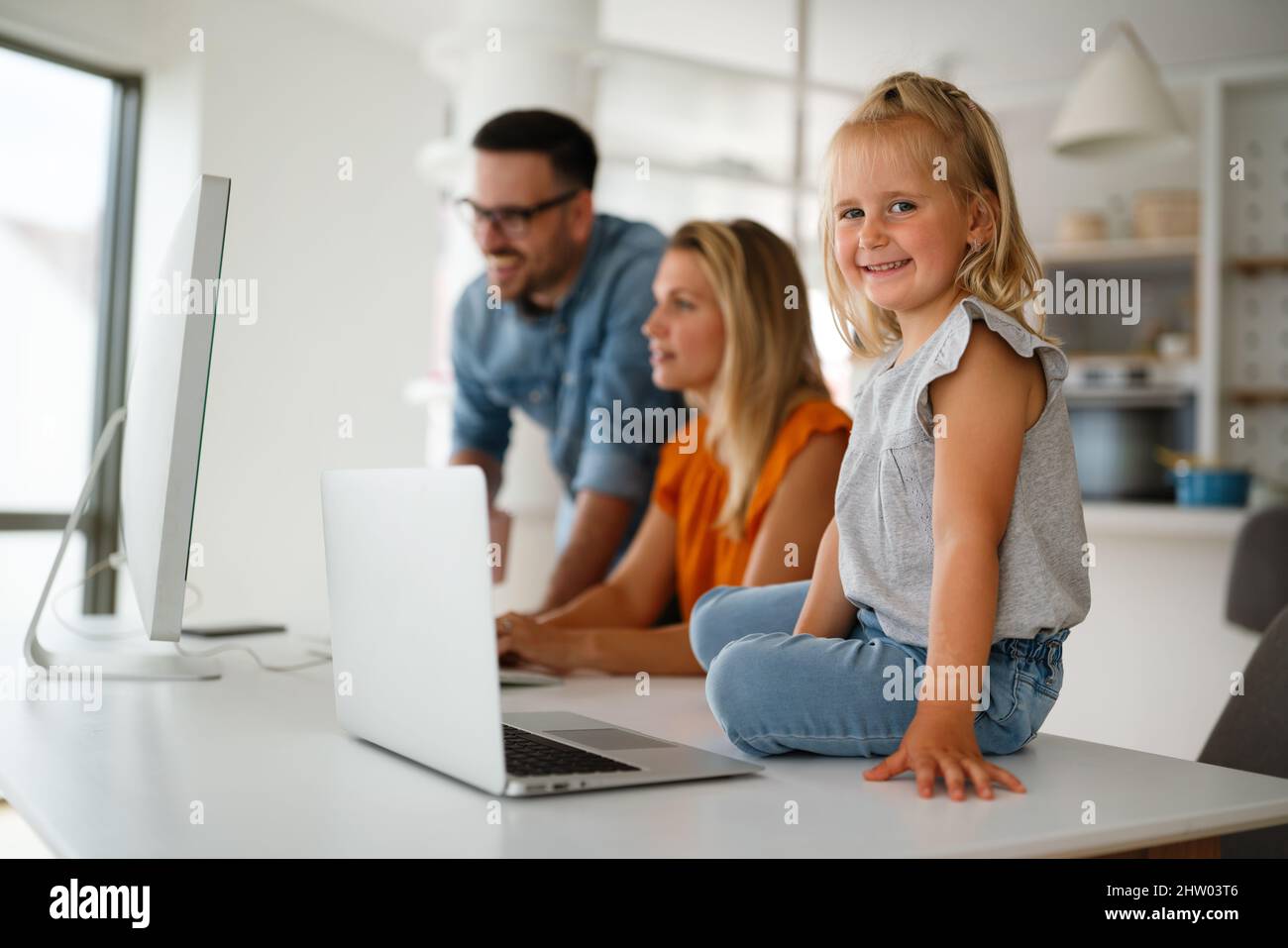 Happy family parent and child at home working on the computer. Business