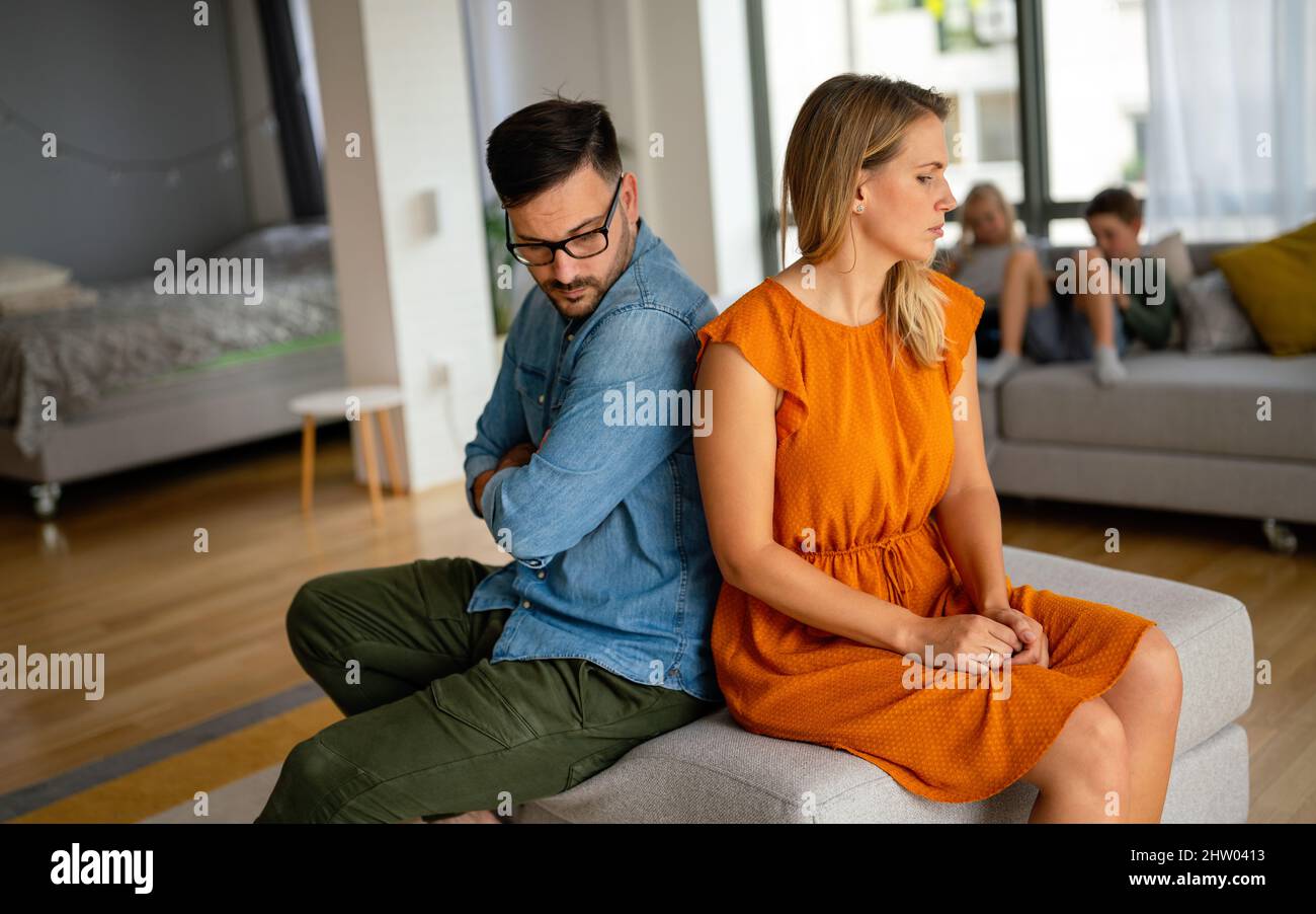 Sad pensive couple thinking of relationships problems sitting on sofa, conflicts in marriage. Stock Photo