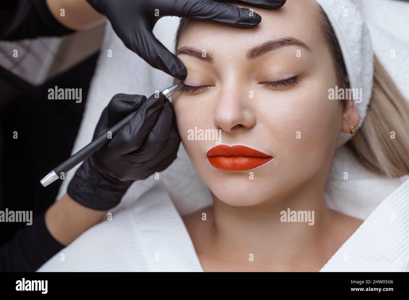 Permanent makeup. Cosmetologist tattoo artist applies a contour to the