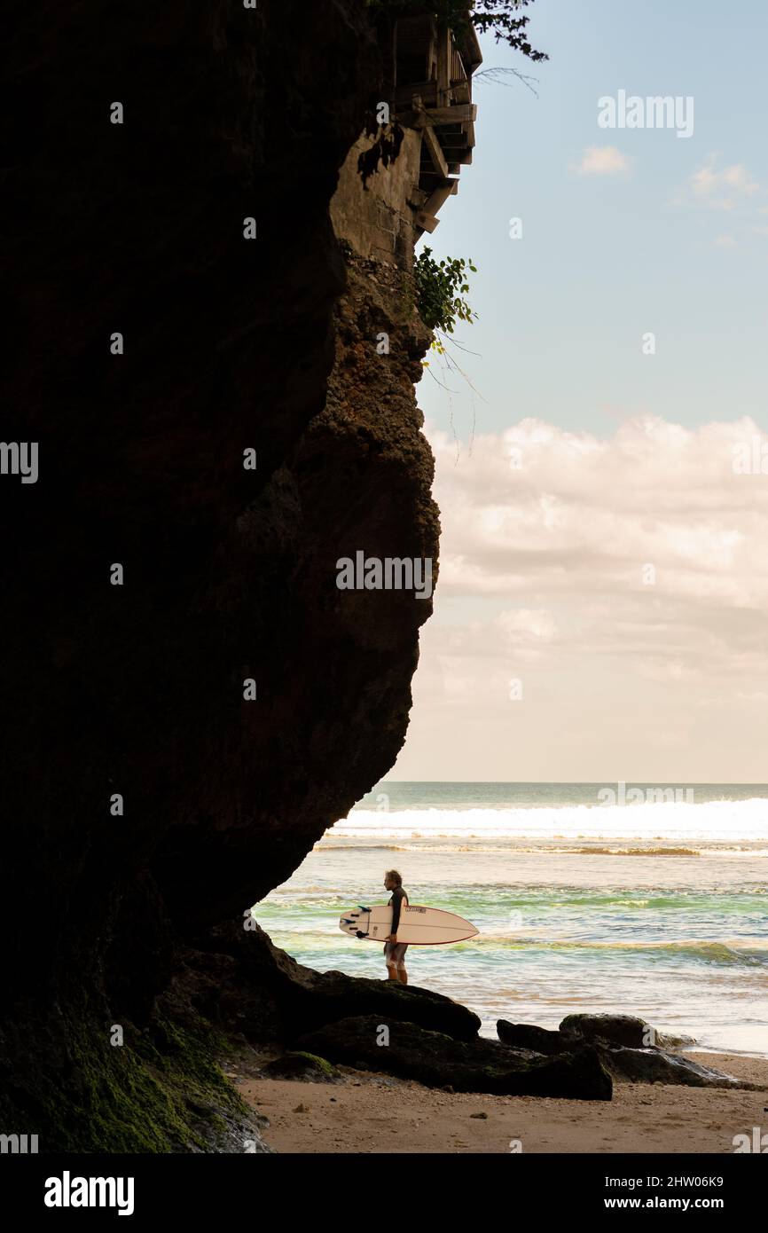 A man walking on the beach with a surfboard Stock Photo - Alamy