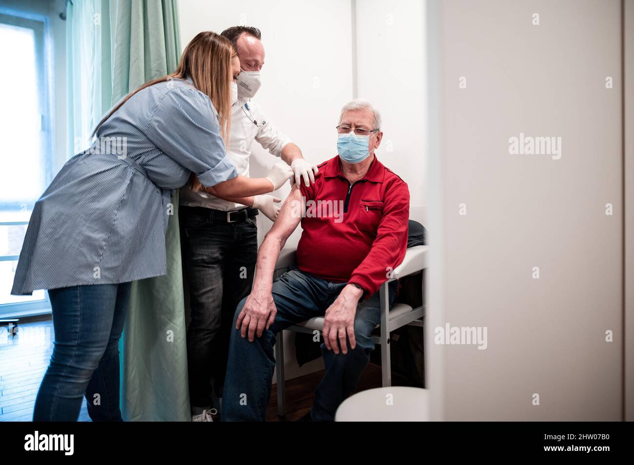 Krefeld, Germany. 03rd Mar, 2022. Physician Christian Einfalt (M) and a helper vaccinate in the rooms of the practice Rüdiger Bauer. The Minister of Health of the state, Laumann, visited the family practice to get an idea of the vaccination process and the daily work routine. Credit: Fabian Strauch/dpa/Alamy Live News Stock Photo