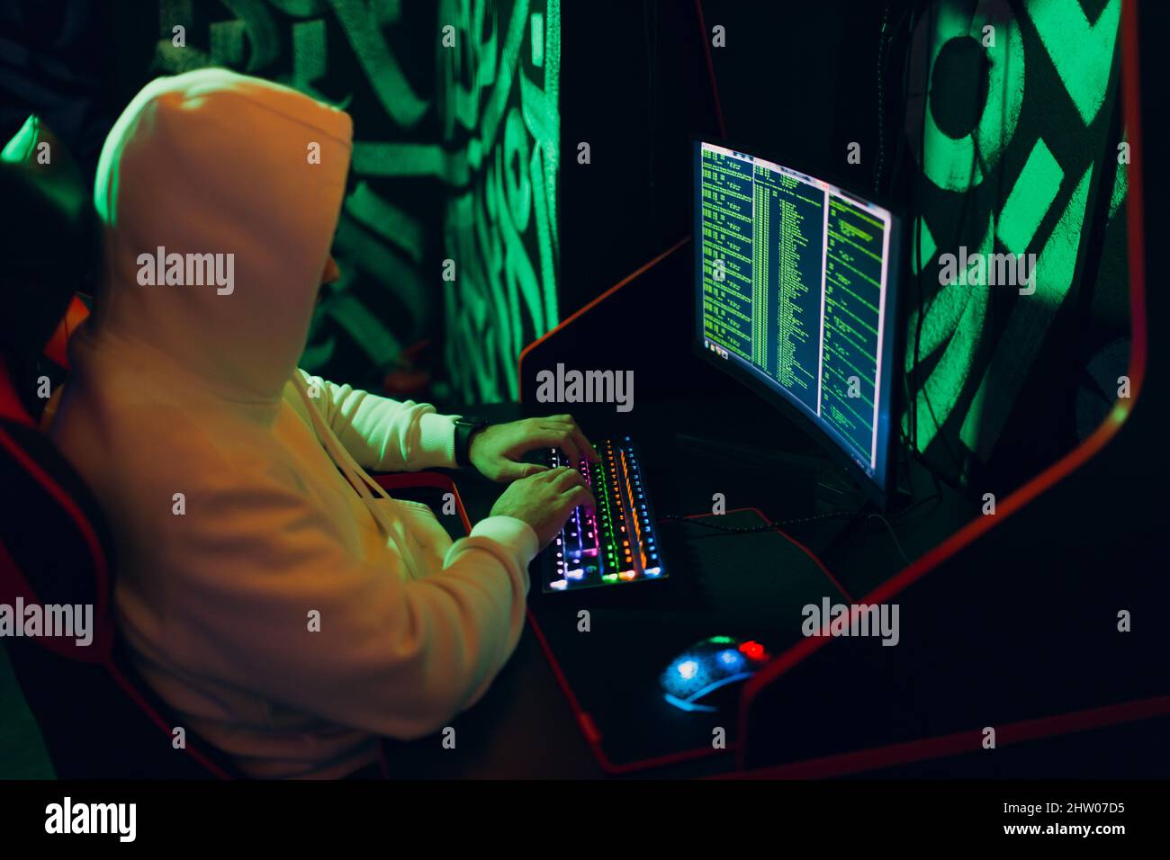 Hacker using computer malware software and hacking binary code green digital interface. Stock Photo