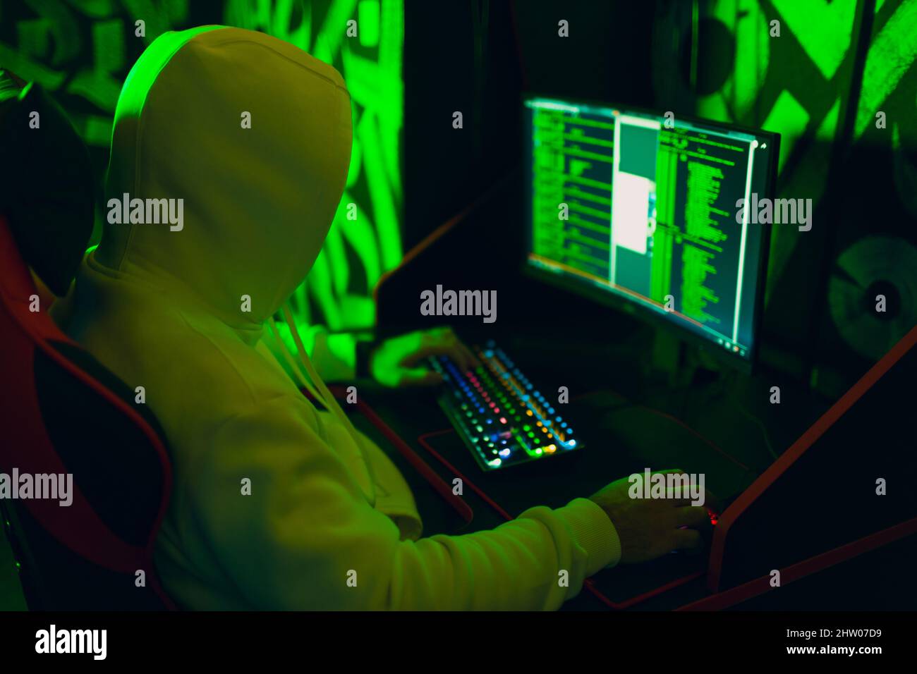 Hacker in hoodie working hacks code site on personal computer. War and cyber attack concept Stock Photo