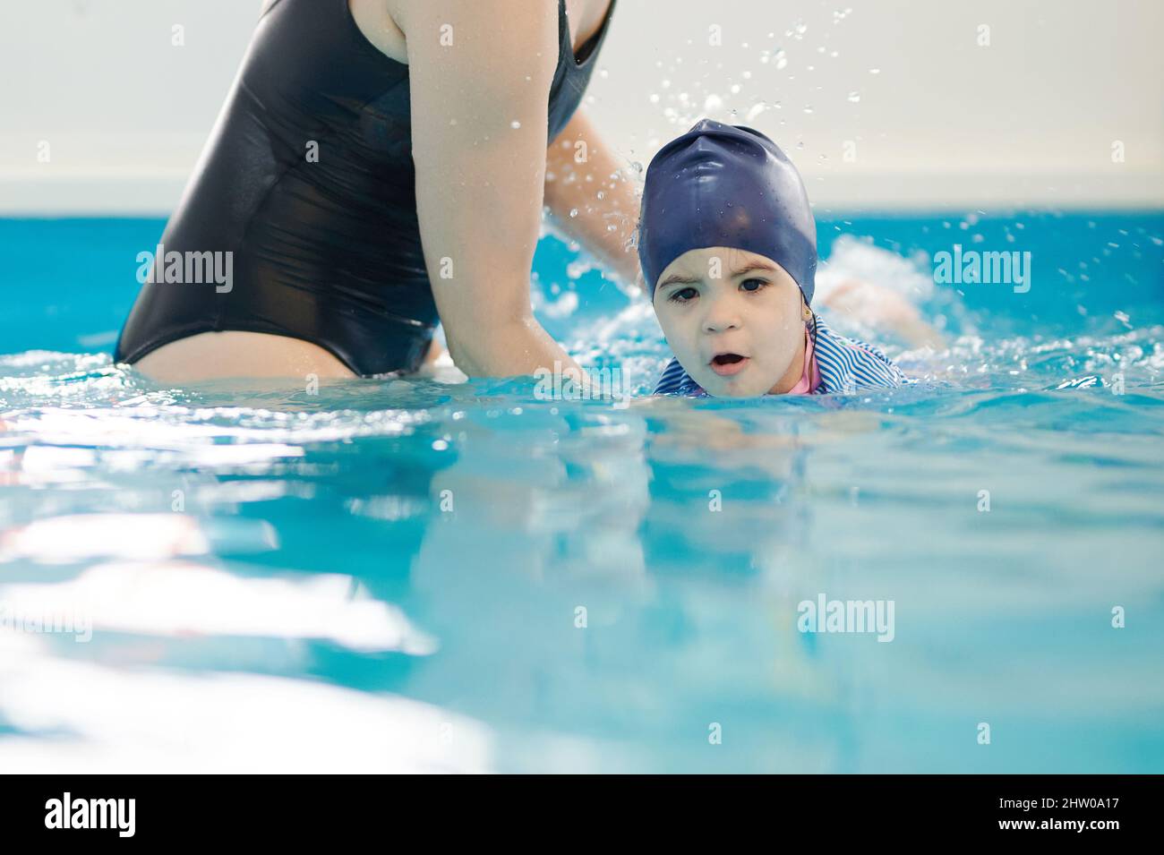 Kid learning to swim with teacher in private lesson preschool Stock Photo