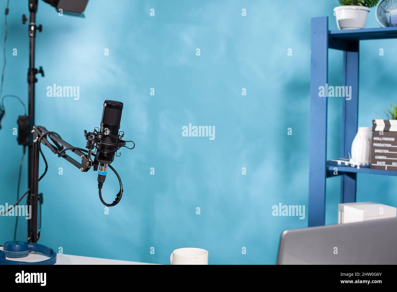Focus on professional microphone swivel boom arm stand in empty podcast