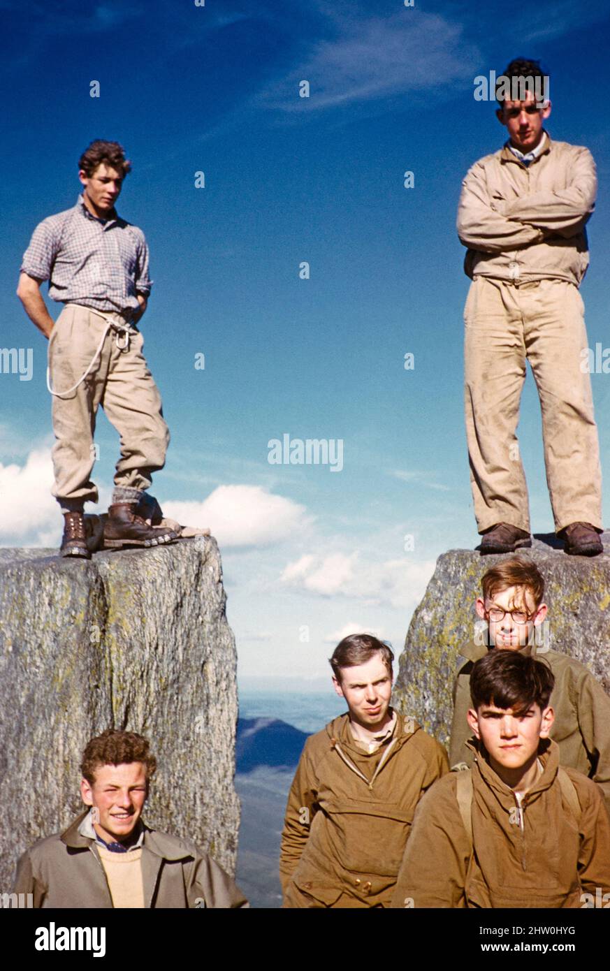 Group of young male rock climbers standing high on rocks, thought to be ...
