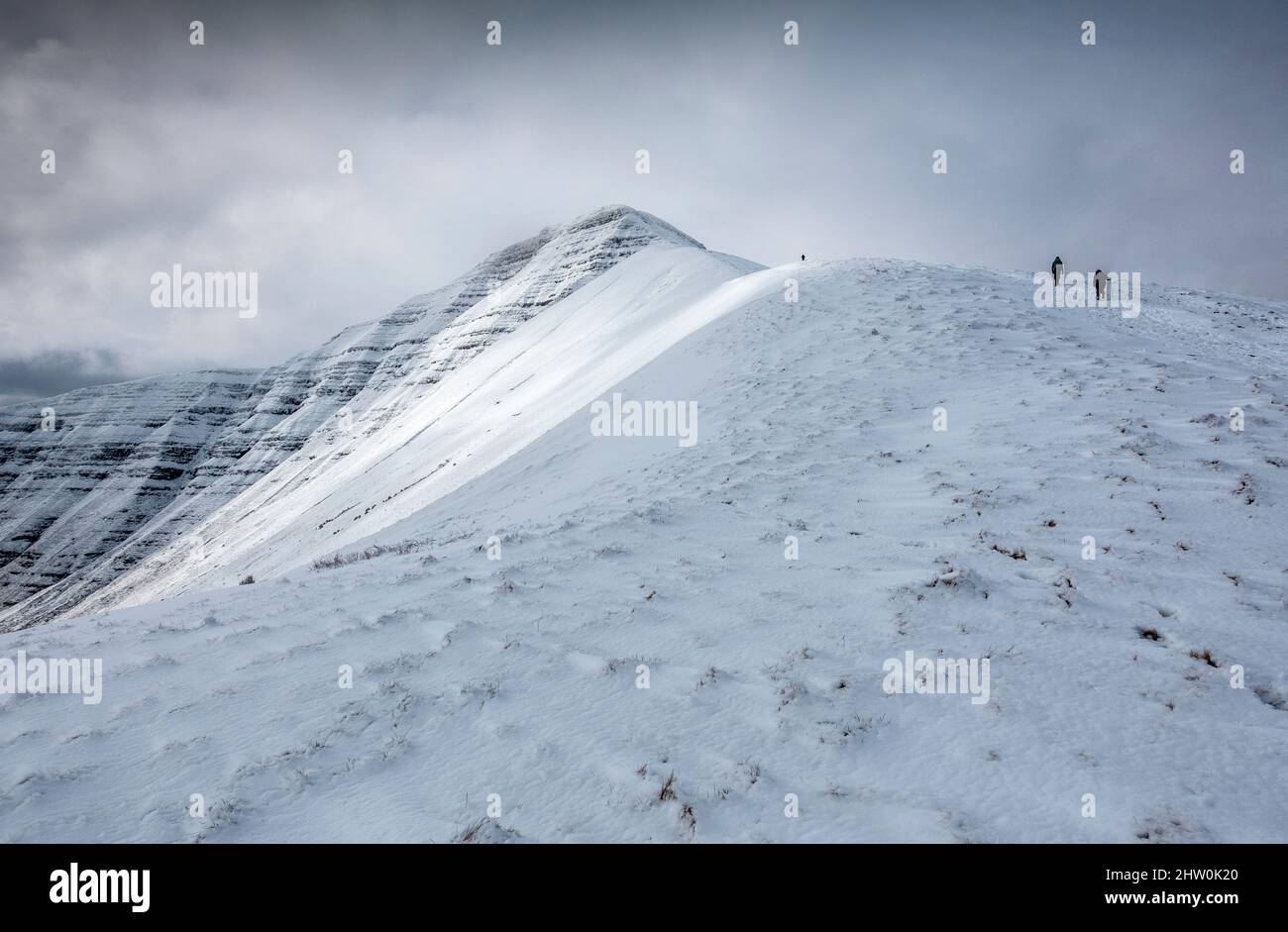 Hikers walking the snow covered Pen Y Fan in the Brecon Beacons National Park, Wales, UK Stock Photo