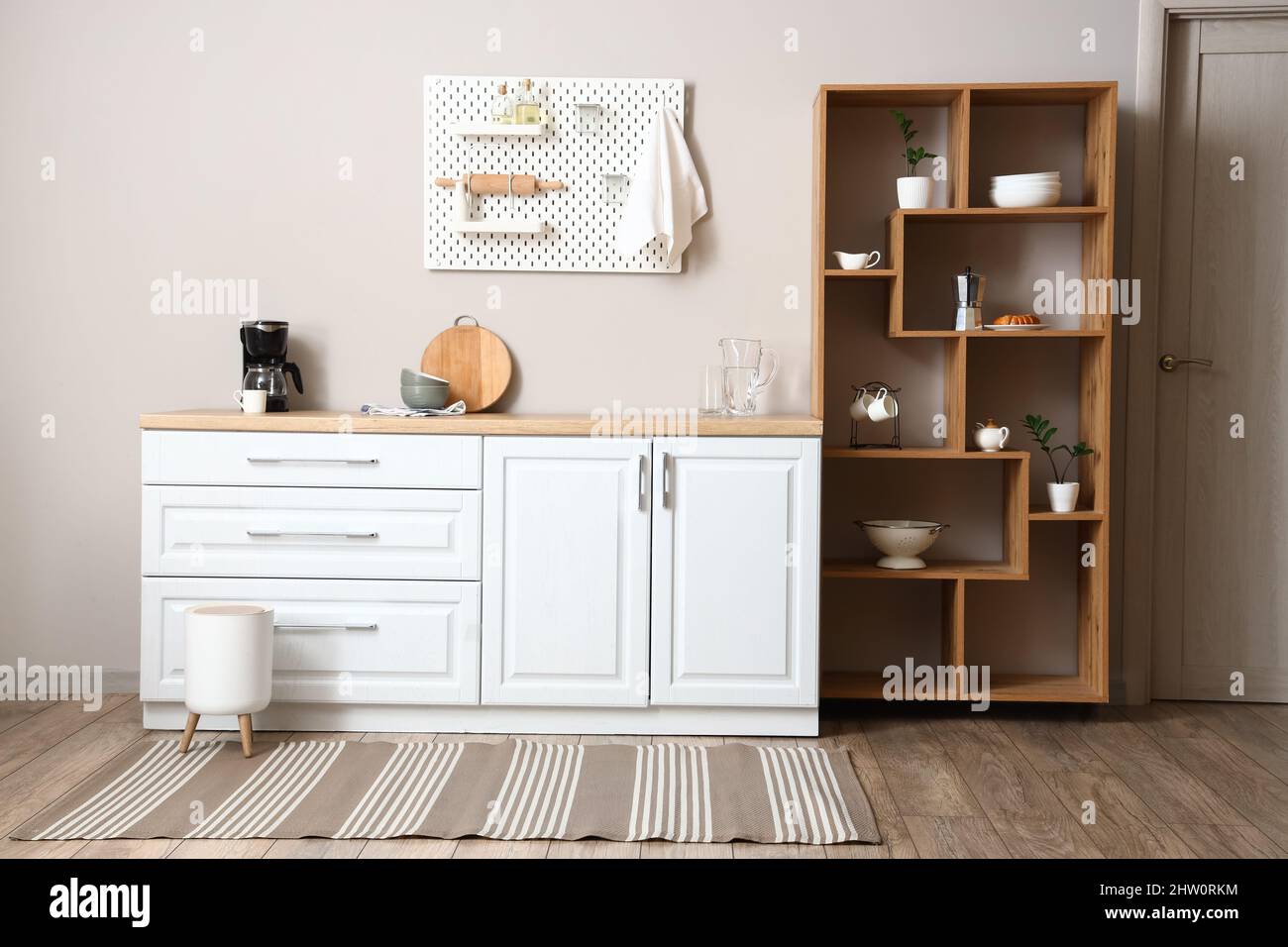 Interior of light kitchen with wooden shelving unit and pegboard Stock ...