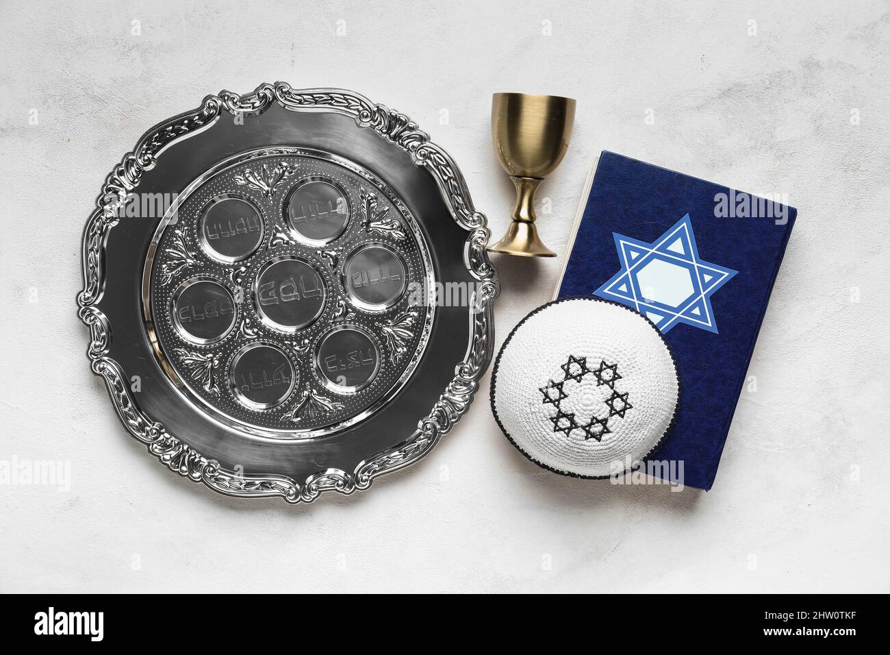 Passover Seder plate, Torah, cup and kippah on light background Stock