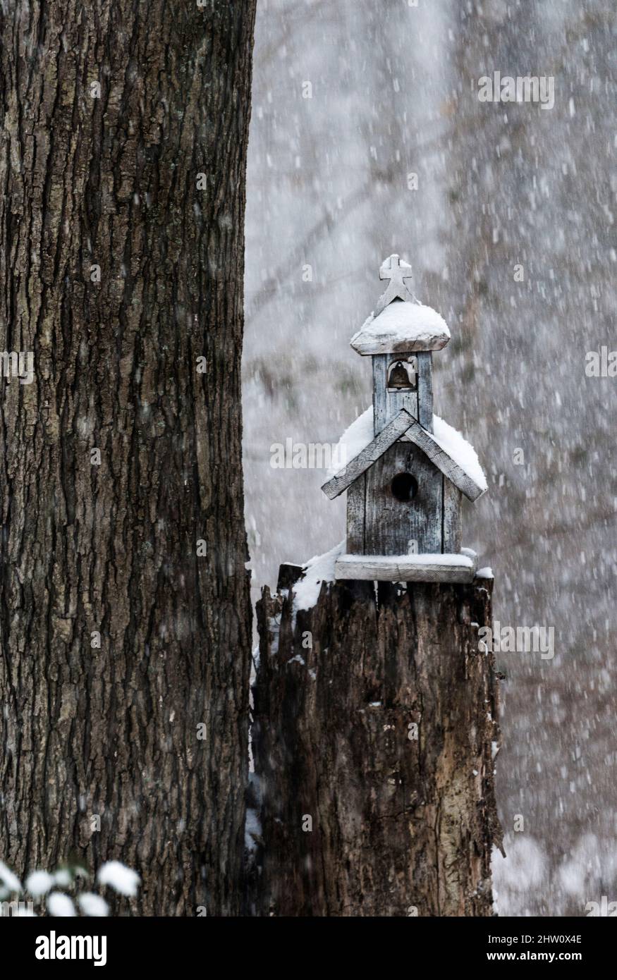 Charming birdhouse chapel in a winter snow storm. Stock Photo