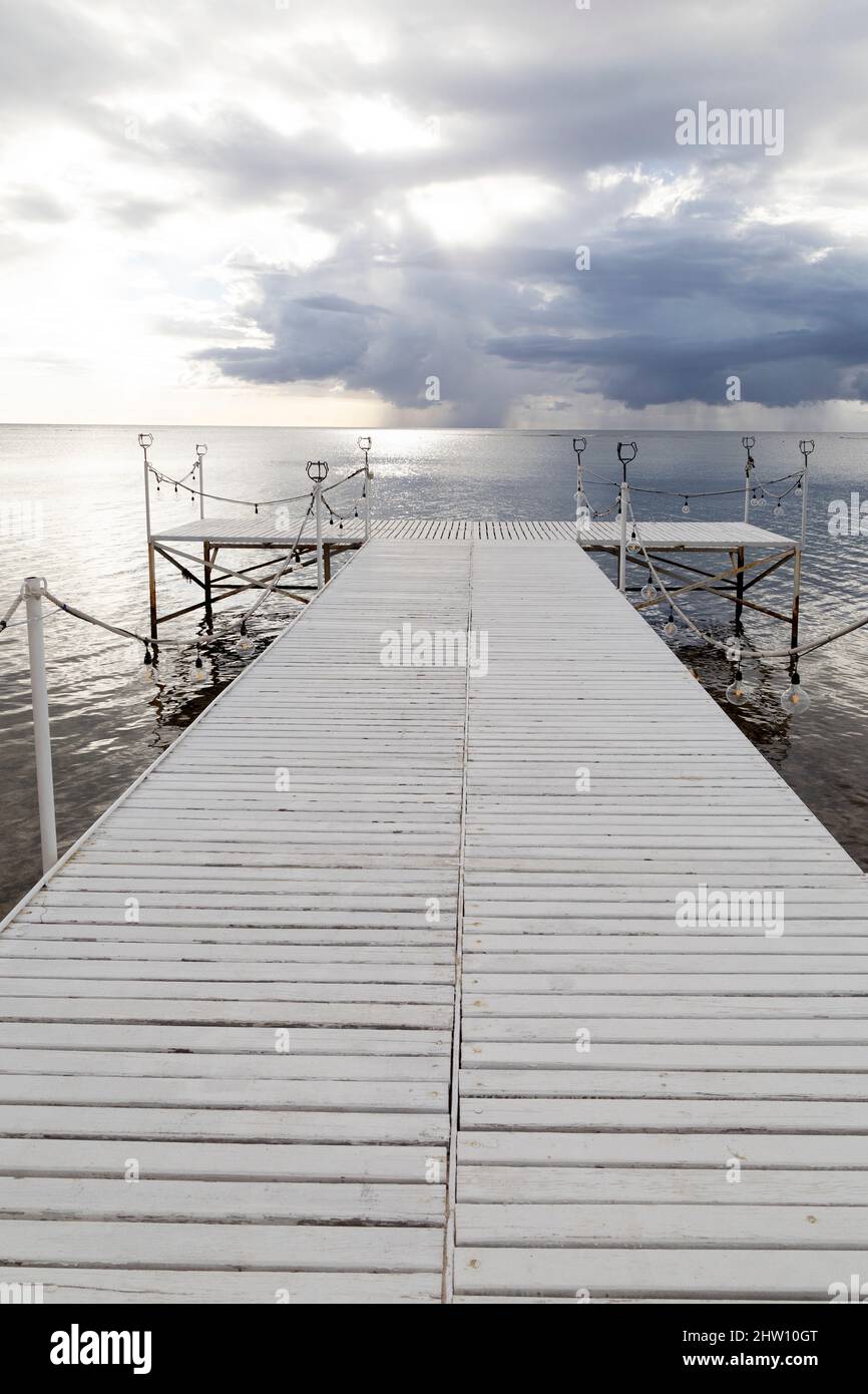 Jetty on the beach at Flic en Flac in Mauritius. Sunlight reflects on the calm water of the Bay of Tamarin. Stock Photo