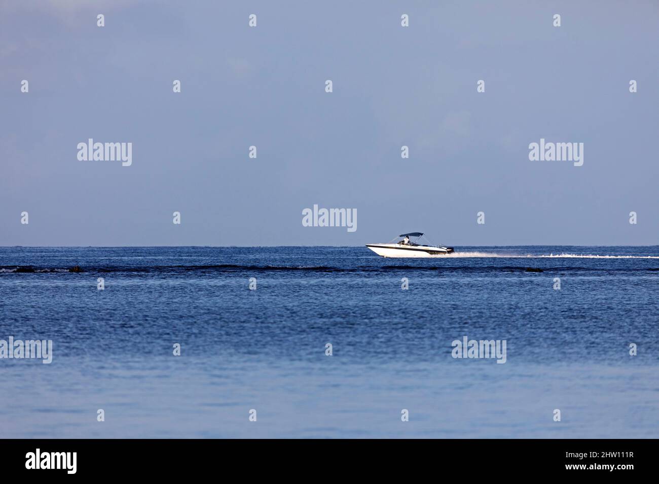 A motorboat speeds through the water of the Indian Ocean off Flic an ...