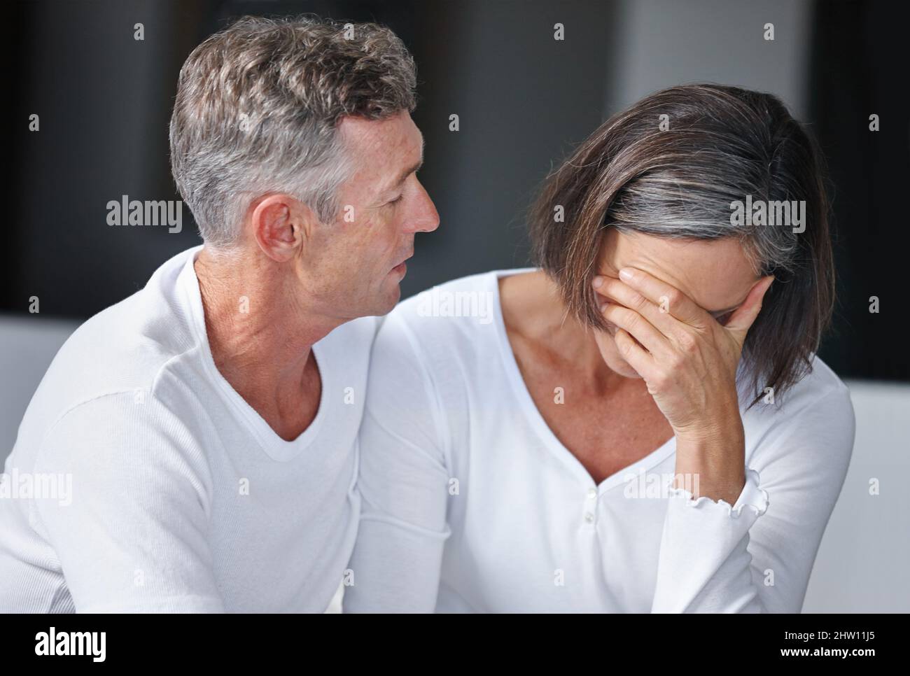 Shes feeling upset. Shot of a mature man sitting beside his wife whos feeling depressed. Stock Photo
