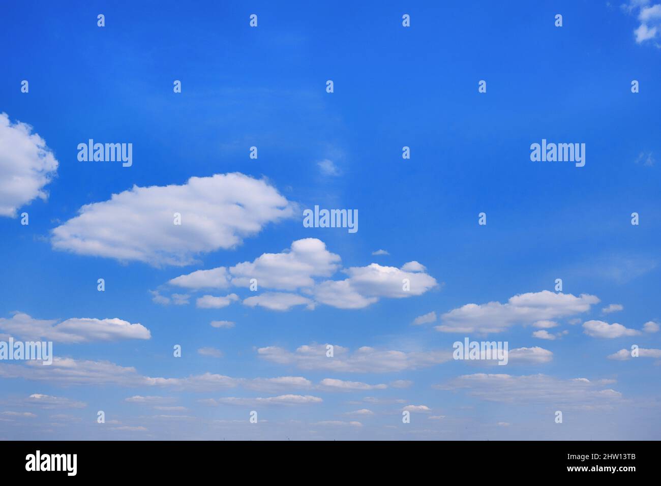 White clouds in clear spring weather. Sunny sky in the morning with