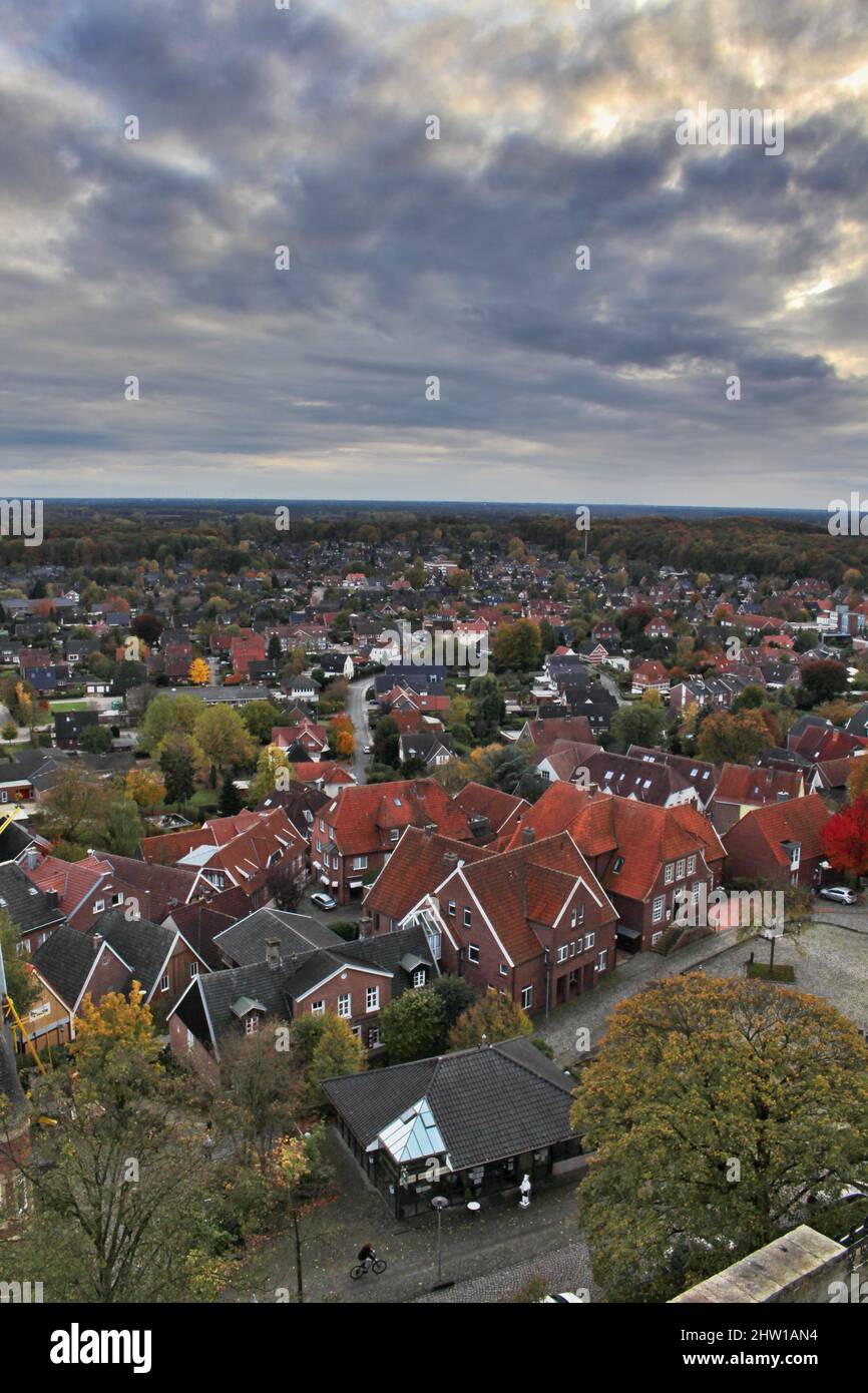 Vertical aerial shot of a cityscape with many buildings under a cloudy ...