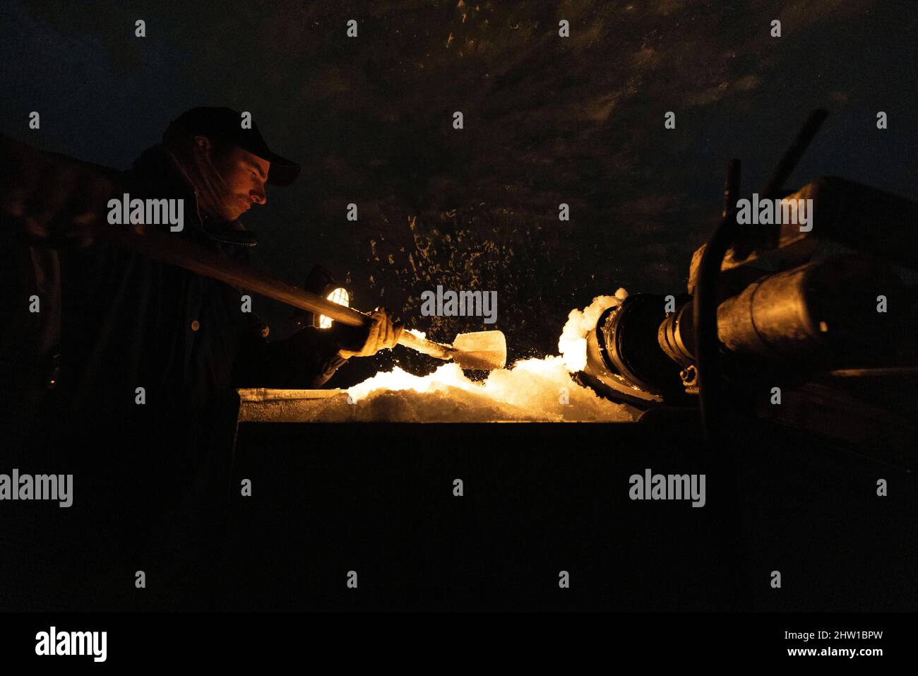 France, Haute-Savoie (74), Chamonix-Mont-Blanc, Mer de Glace cave, Montenvers, Digging of the new cave, The ice is evacuated on a small conveyor belt to the wagon which evacuates it outside, Kevin packs the snow in the wagon before evacuating it outside the cave, Stock Photo