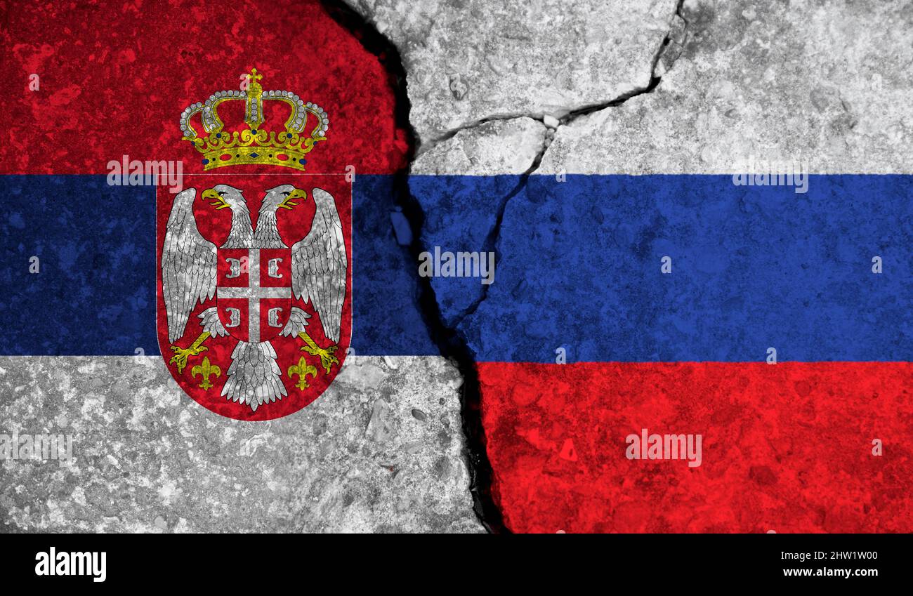 Political relationship between Serbia and russia. National flags on cracked concrete background Stock Photo