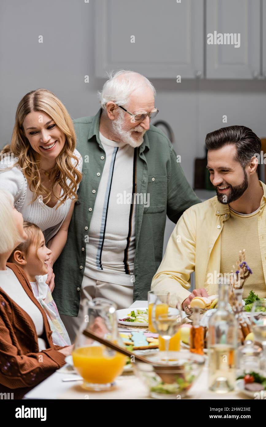 happy family smiling near table served with eastern dinner,stock image Stock Photo