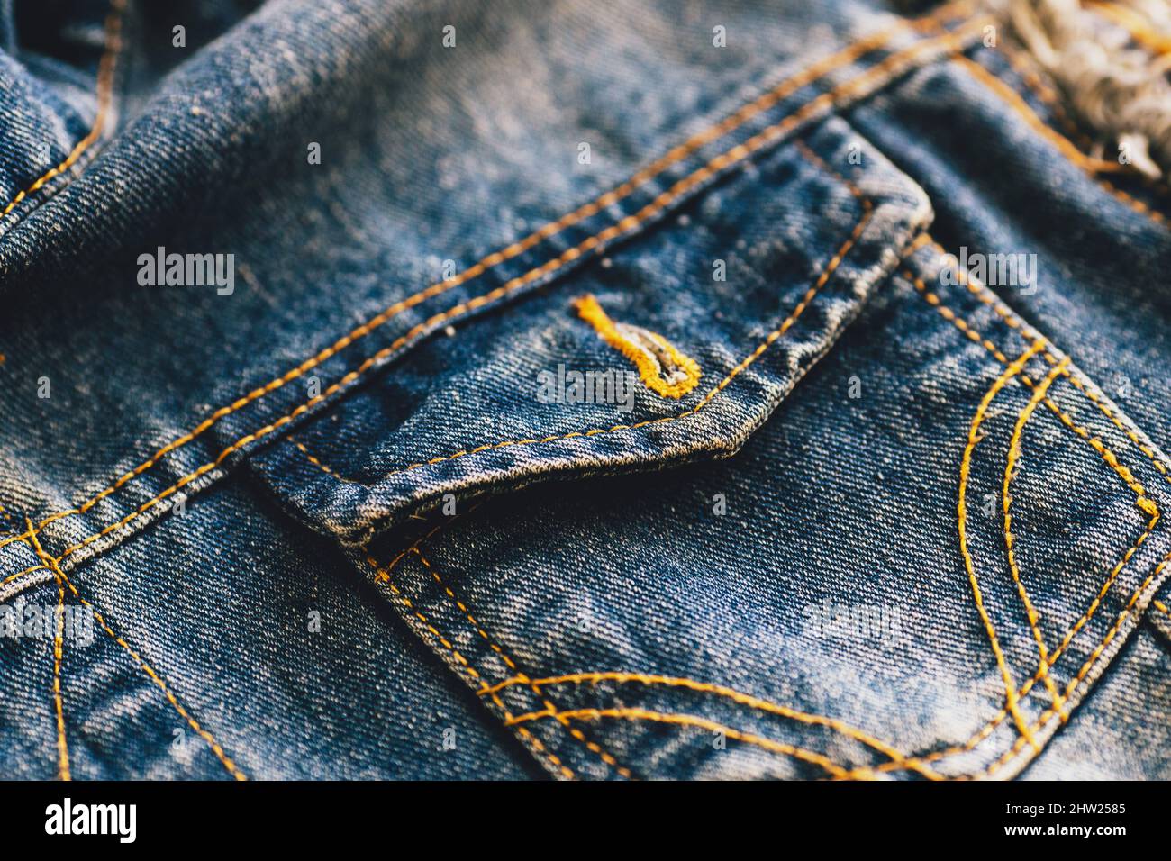 Pocket of denim jacket is blue in close-up. Advertising background of manufacturer of denim clothing or supplier of denim fabric. Copy space. Stock Photo