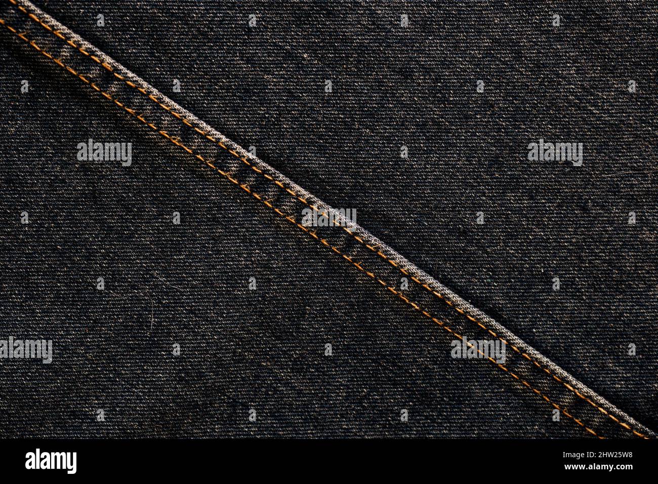 Fashionable denim with stitching. Textile material. Empty surface with space to copy. Part of clothes. View from above. Stock Photo