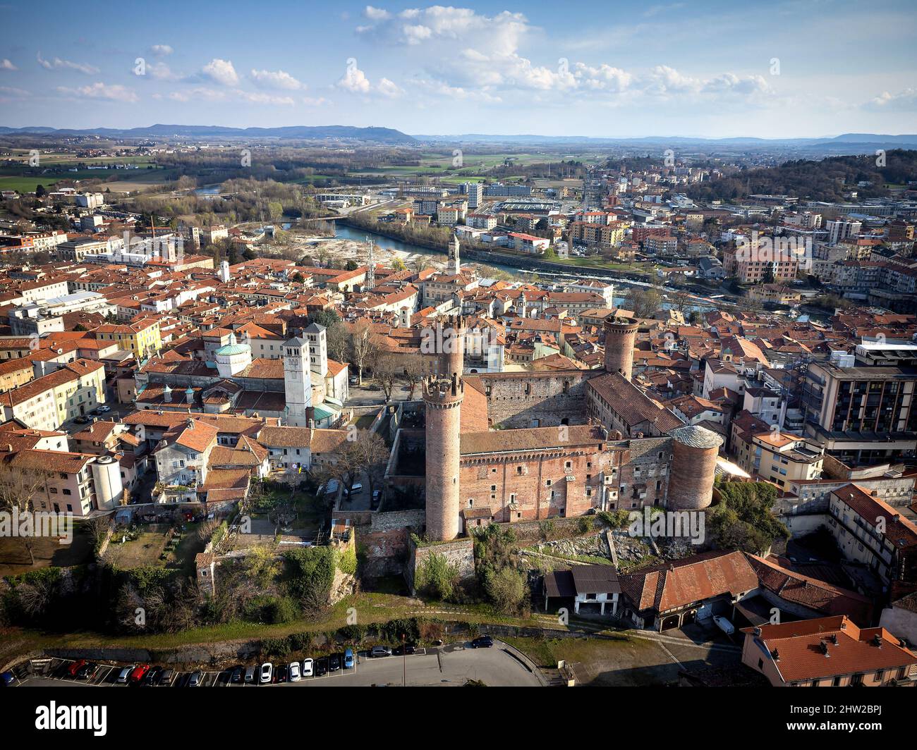 Aerial view of the historic centre with the Castle with its red towers in the foreground. Ivrea, Italy - March 2021 Stock Photo