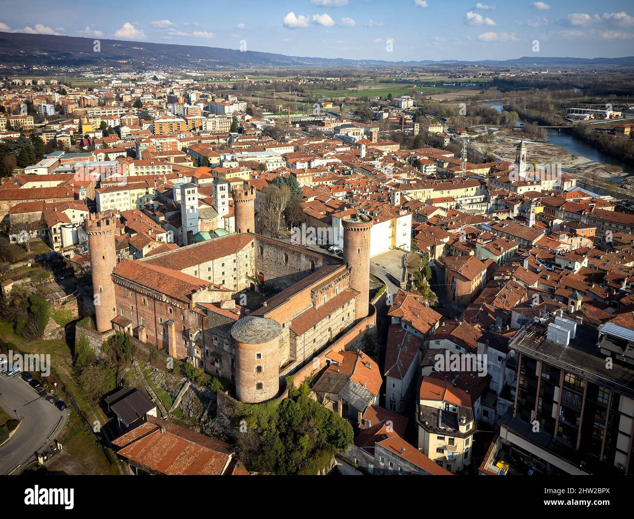 Aerial view of the historic centre with the Castle with its red towers in the foreground. Ivrea, Italy - March 2021 Stock Photo