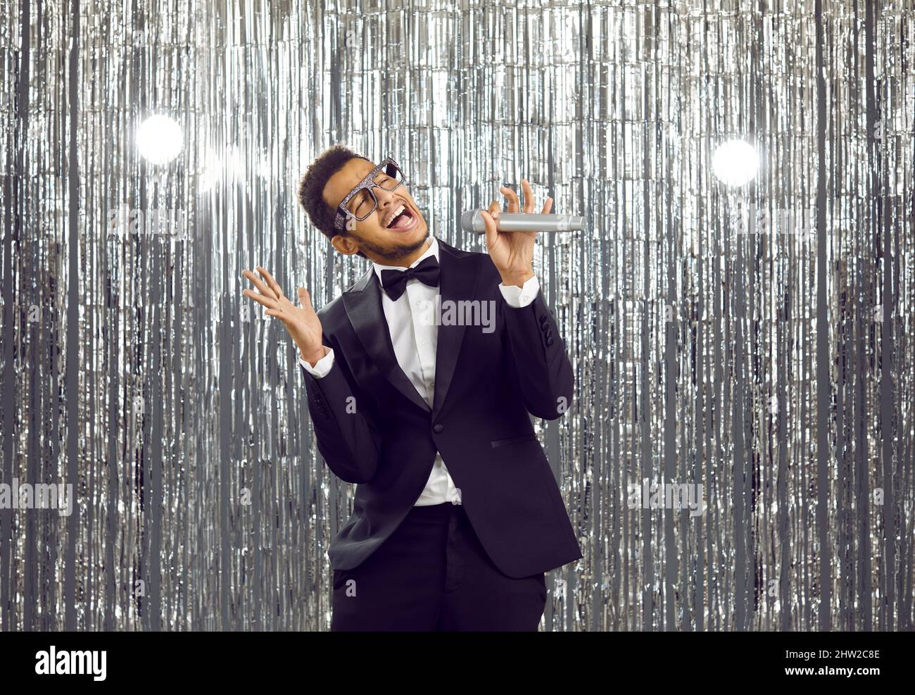 Smiling black man sing karaoke in mic Stock Photo