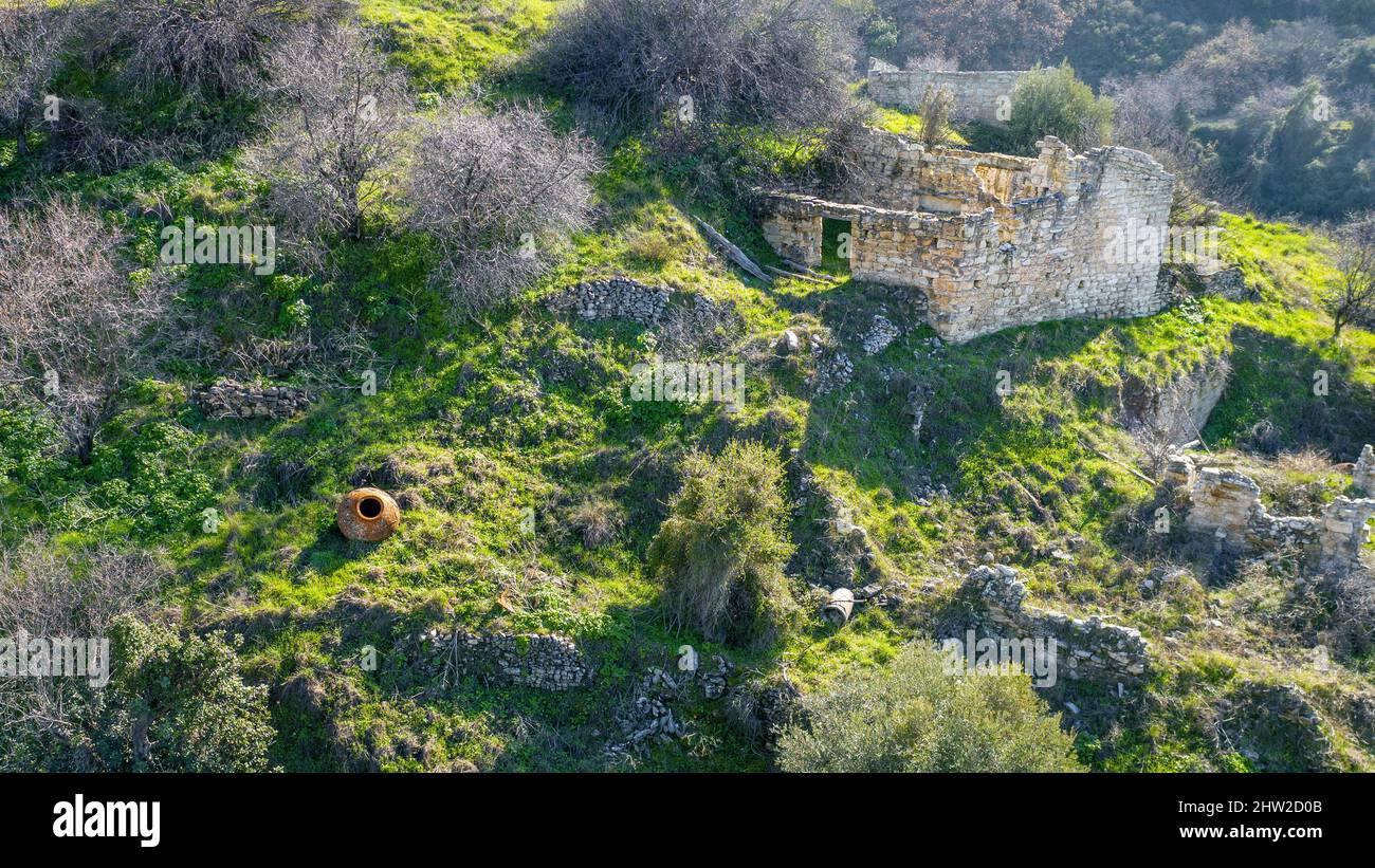 Ruins of abandoned old stone house with no roof in traditional village in Mediterranean landscape Stock Photo