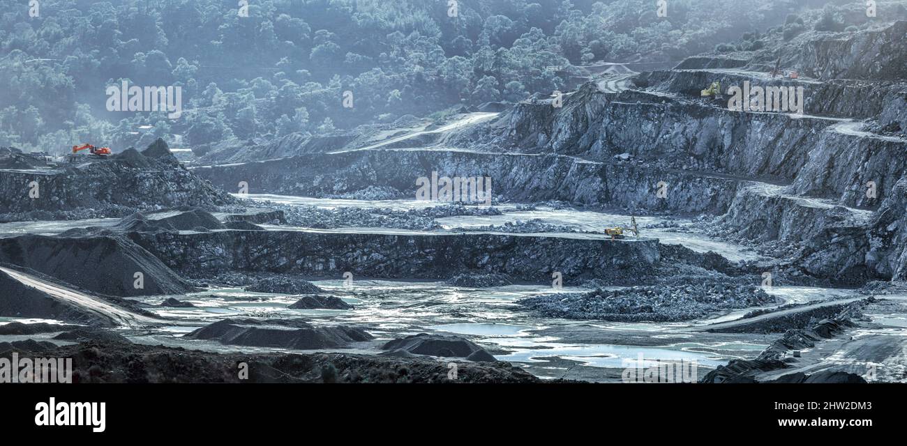 Mining machines and piles of crushed stone in diabase quarry (Cyprus), industrial landscape Stock Photo