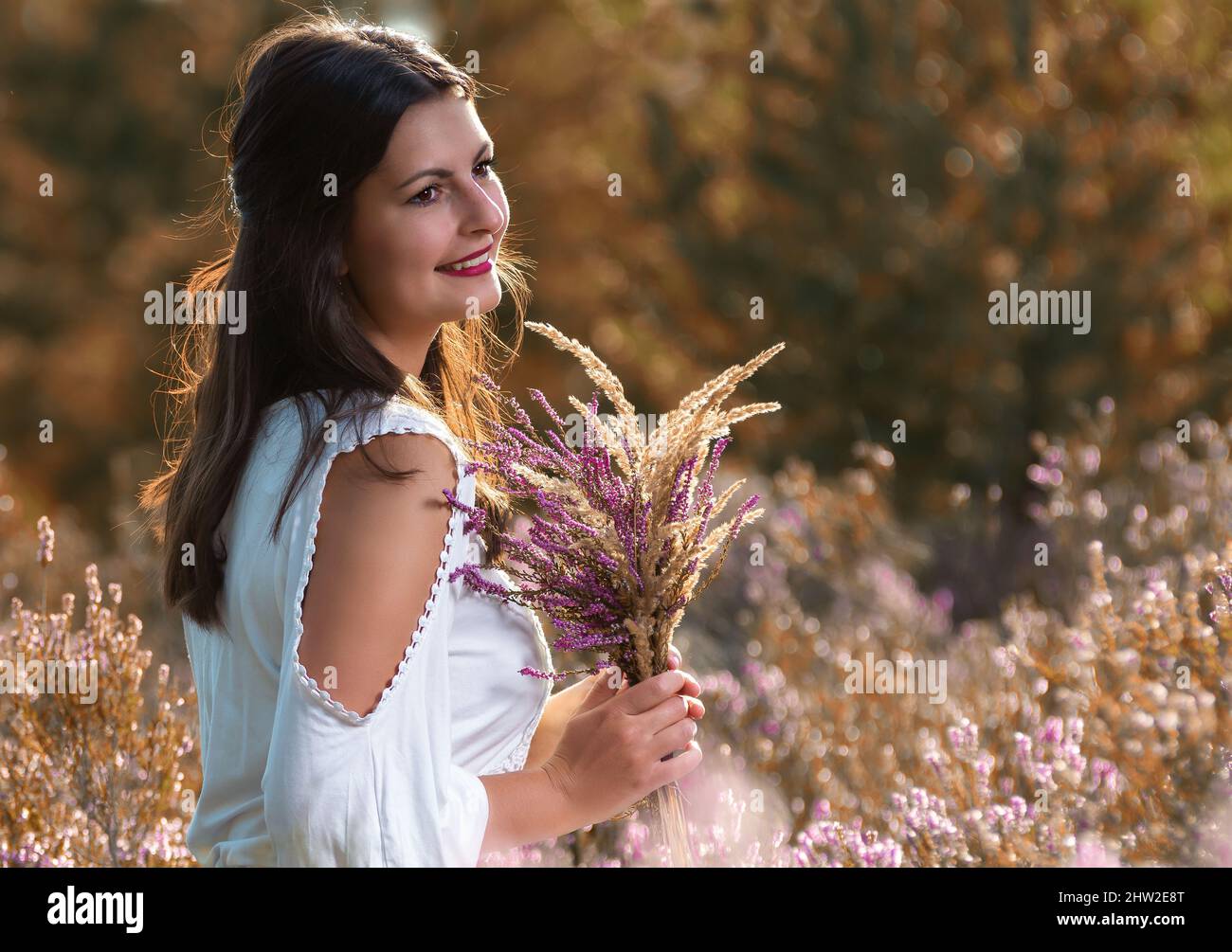 Grateful heather girl with a bouquet of flowers Erika Stock Photo Alamy