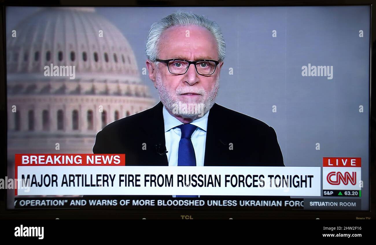 A TV screenshot of CNN news anchor Wolf Blitzer reporting on the